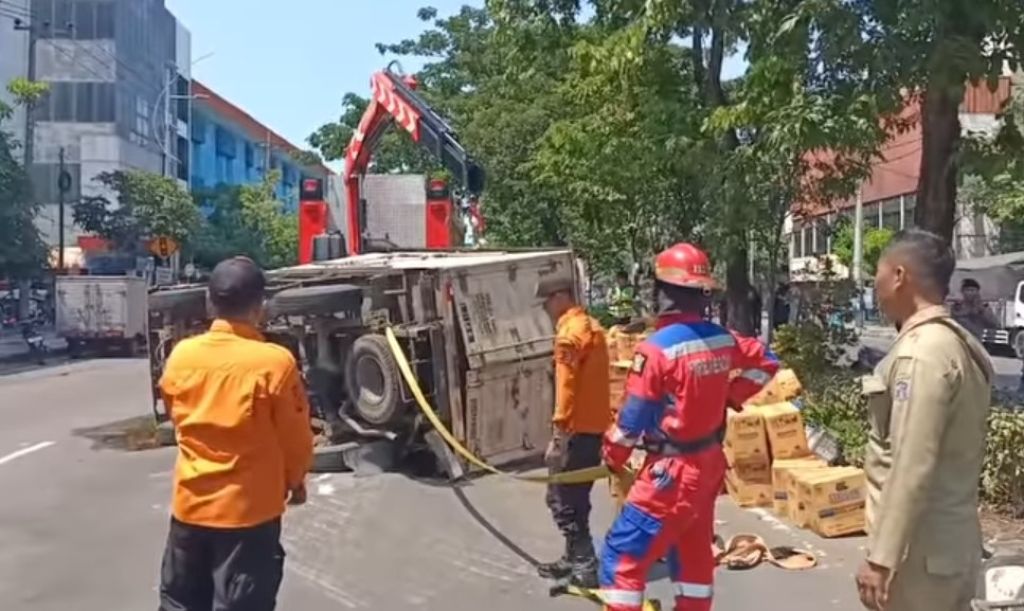 Truk Bermuatan Air Radiator Terguling di Jalan Tembaan Surabaya
